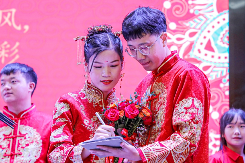 新人在移风易俗承诺书上签名。曾恒贵摄