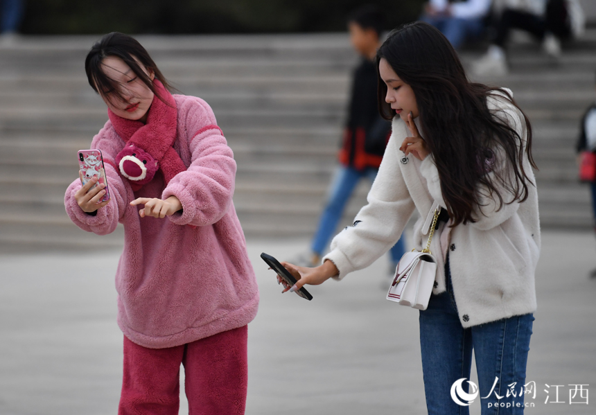 国庆假期后期，江西气温骤降，市民和游客着秋装出行。 人民网 时雨摄