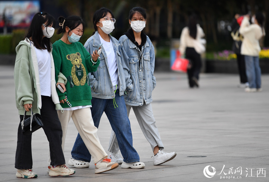 国庆假期后期，江西气温骤降，市民和游客着秋装出行。 人民网 时雨摄