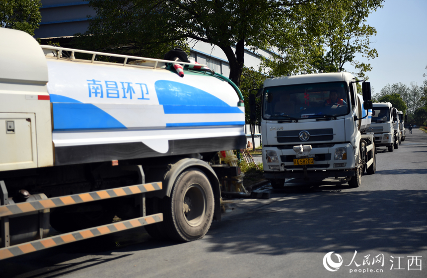 環衛車正在排隊灌裝中水，准備進行路面作業。 人民網 時雨攝