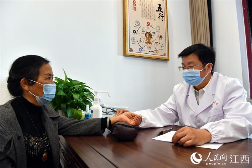 义诊的名中医为患者把脉。 人民网 时雨摄
