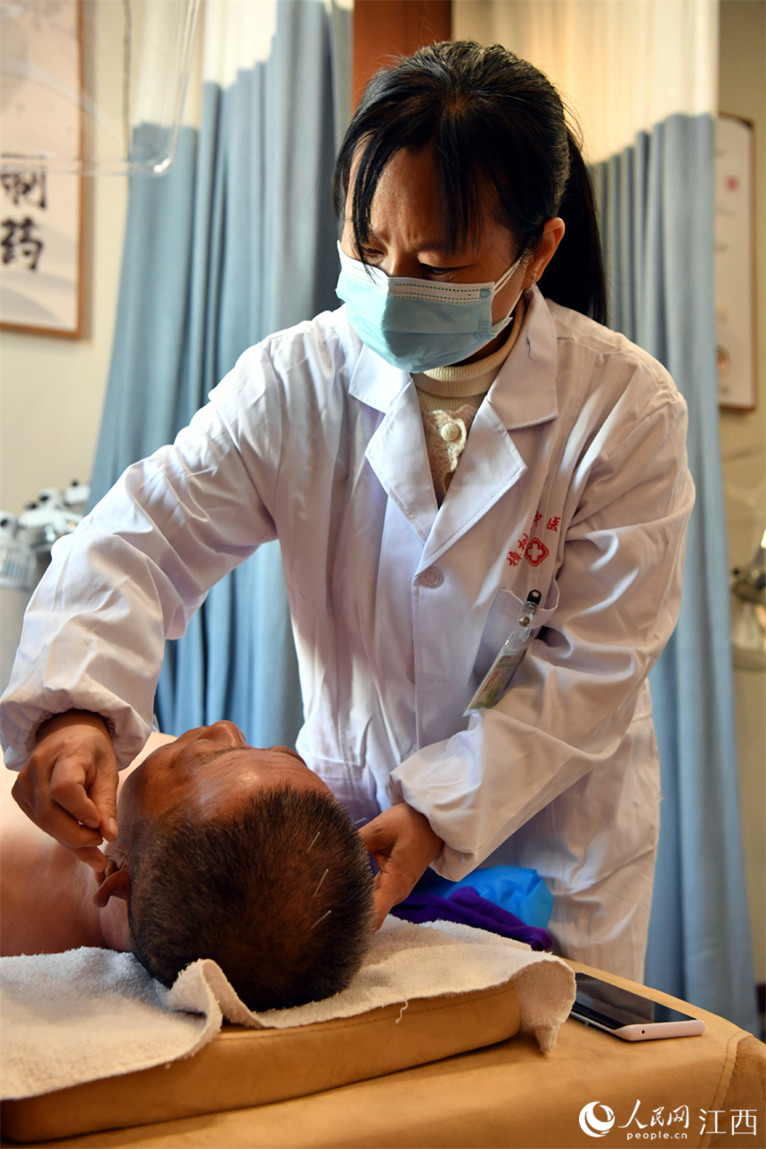 义诊的名中医为患者针灸。 人民网 时雨摄