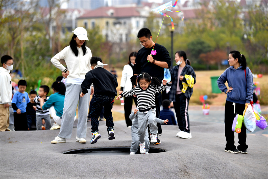 秋日暖阳下，孩子们在公园内快乐玩耍。 人民网 时雨摄