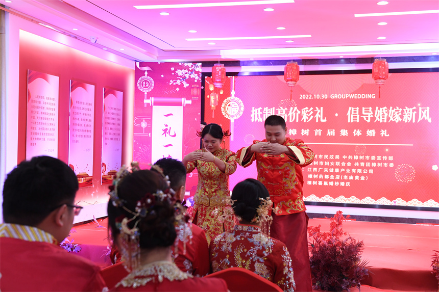 新人向前来参加婚礼的嘉宾们作揖行礼。 张瑄摄