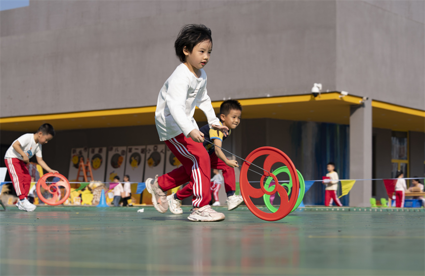 孩子们参加滚铁环比赛。赵春亮摄
