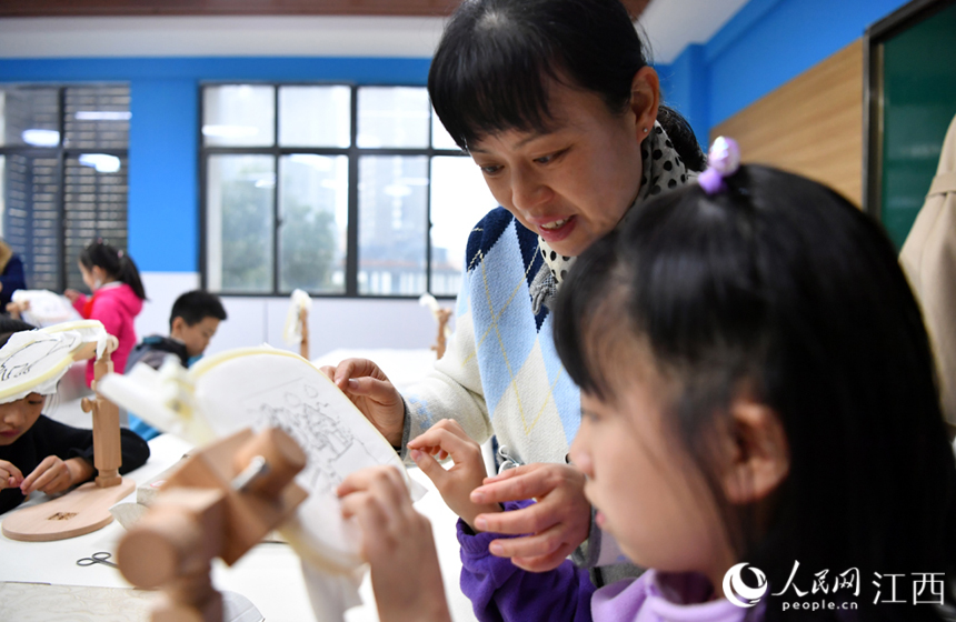 非遗工坊的老师正在教学生在宣纸上刺绣。 人民网 时雨摄