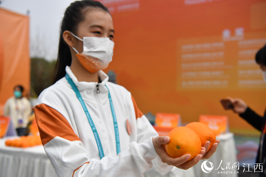 志願者展示“臍橙王”。 人民網 時雨攝