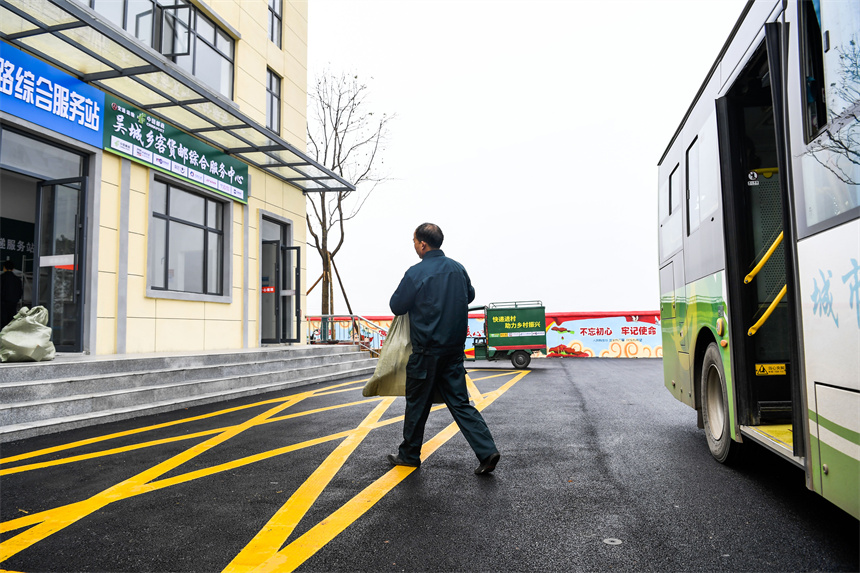 江西省樟樹市吳城鄉客貨郵綜合服務中心，快遞員將公交車上的快遞拿下車。周亮攝