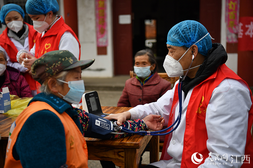 社区卫生服务中心的医生为有基础疾病的村民测量血压。 人民网 时雨摄