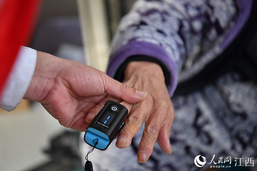 社区卫生服务中心的医生来到村民家，为年老的村民测量血氧。 人民网 时雨摄