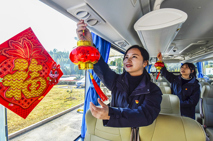 青年党员给公交车挂上喜庆的灯笼。吴志贵摄