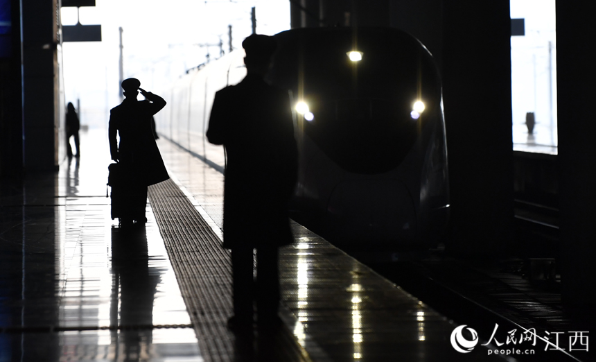 南昌西站，動車司機在站台迎接春運的列車進站。人民網 時雨攝