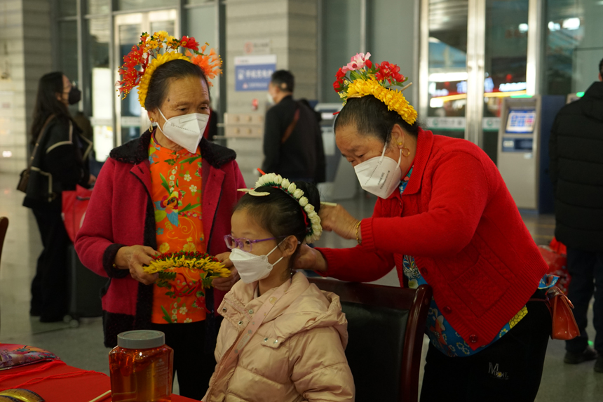 蟳埔女為小旅客戴簪花圍。陳明攝