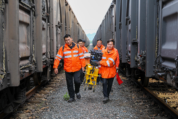铁路职工正在搬运仪器到探伤作业地点。中国铁路南昌局集团有限公司供图
