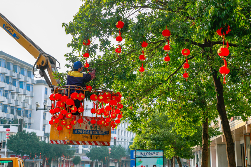 市政工人在江西省贛州市全南縣城區街道懸挂紅燈籠。李凡欽攝