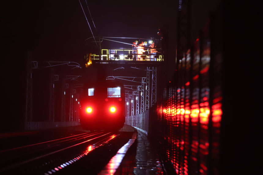 1月10日凌晨0点30分，平潭海峡公铁大桥上接触网工们在雨中为海鸟“搬家”。李昊摄