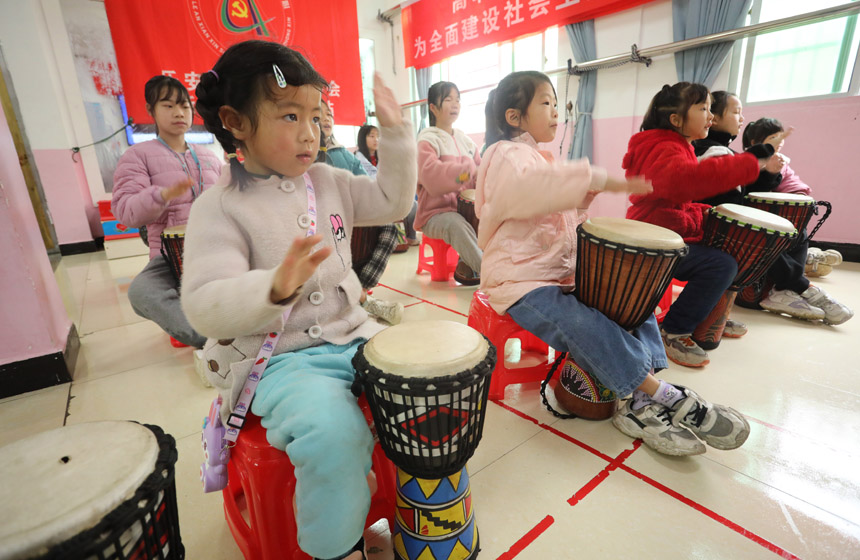 1月13日，在江西省抚州市乐安县惠民家园小区内，陪留守儿童们正在学习拍非洲鼓。邱志超摄