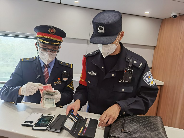 列车长蒋文雄和乘警清点旅客遗失物品。