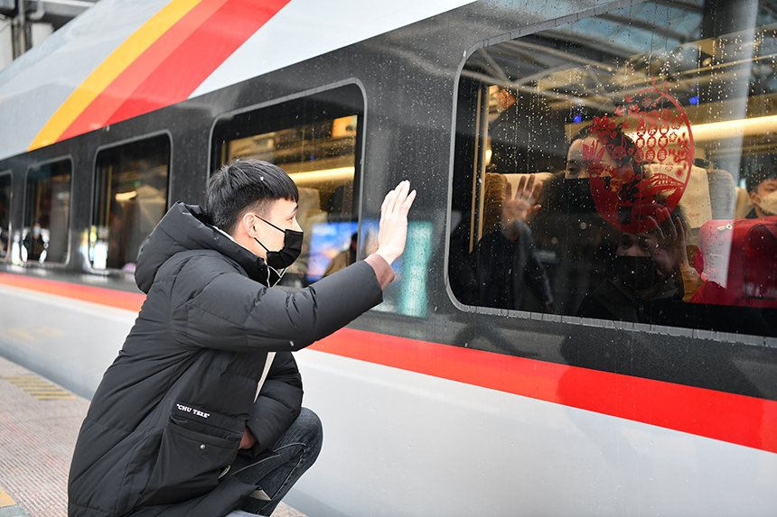 在南昌西站一名旅客正向车内乘客挥手告别。 郭钰祺摄