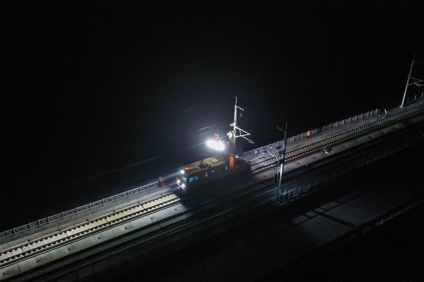凌晨，接触网工们乘坐作业车抵达鳊鱼洲长江大桥开展作业。郭钰祺摄