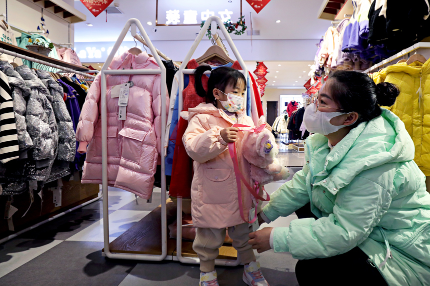市民在江西省宜豐縣紅商城童裝店選購新衣裳。何賤來攝