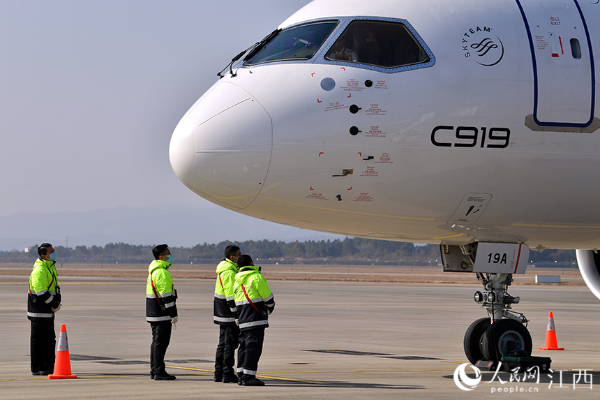 地勤人员驻足观赏C919国产大飞机。 人民网 时雨摄