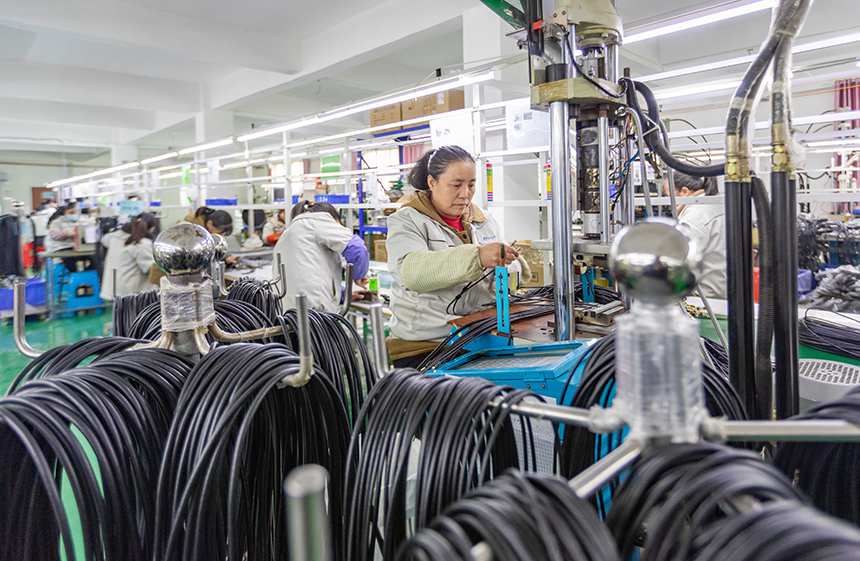 图为在永新县一电子企业生产车间内，工人在赶制订单产品。周亚茂摄