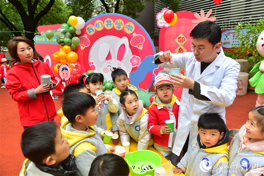 开学第一天，南昌市东湖区出新幼儿园的孩子们和社区志愿者一起互动科学实验《冬雪变奏曲》。 人民网 时雨摄