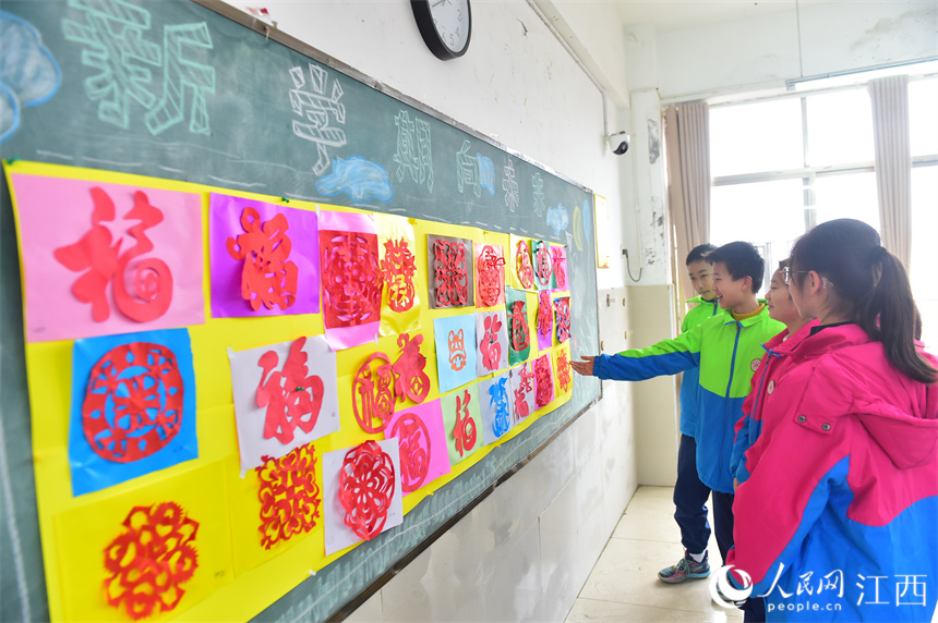 南昌东湖区的育新学校教育集团，教室的黑板上贴着学生们的剪纸作品。 人民网 时雨摄