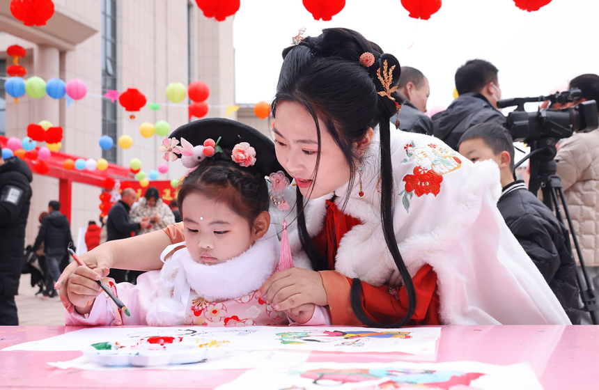 2月2日，江西省宜春市上高县文化广场，文化馆职员正在指导孩子绘制手工DIY。陈旗海摄
