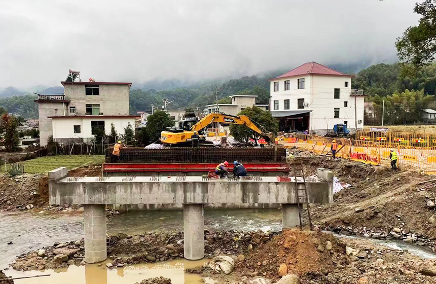 施工人员顶着阵阵毛雨在古阳寨桥梁建筑工地作业。郭祥峰摄