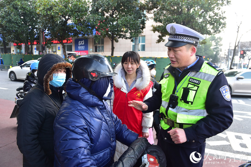 志願者們協助交警對騎乘電動車不佩戴安全頭盔、逆行等不文明交通行為進行勸導。 人民網 時雨攝