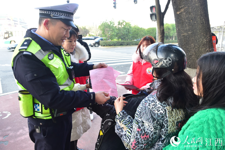 志願者們協助交警對騎乘電動車不佩戴安全頭盔、逆行等不文明交通行為進行勸導。 人民網 時雨攝