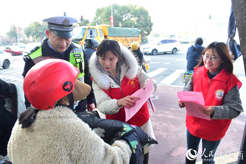 志願者們協助交警對騎乘電動車不佩戴安全頭盔、逆行等不文明交通行為進行勸導。 人民網 時雨攝