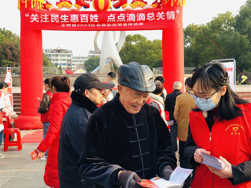 工作人員向前來咨詢的市民派發宣傳資料，面對面為群眾解讀社會救助政策。劉平華攝