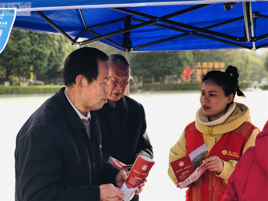 工作人員向前來咨詢的市民派發宣傳資料，面對面為群眾解讀社會救助政策。劉平華攝