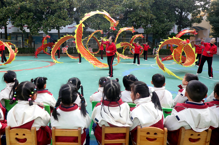 在宜丰县新昌大道旁的宜丰幼儿园，孩子们观看“彩带龙”表演。何贱来摄