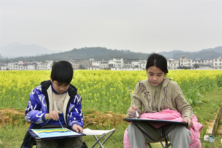學生在金色的花海中創作。劉榮東攝