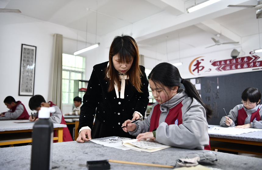 学生在江西省赣州市兴国县第五中学的延时课堂中学习书法。陈淑蓉摄