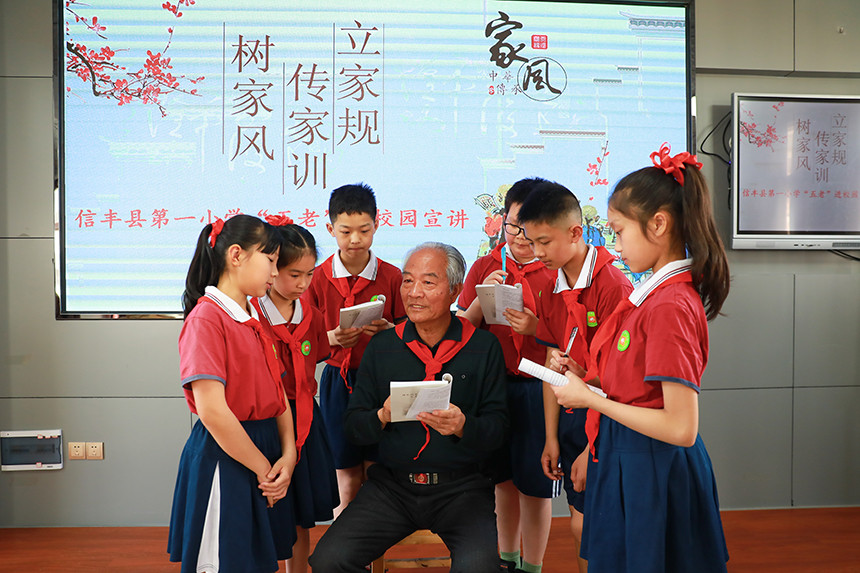 袁守根在信豐縣第一小學，向少先隊員們講述雷鋒生平故事。陳蘇冰攝