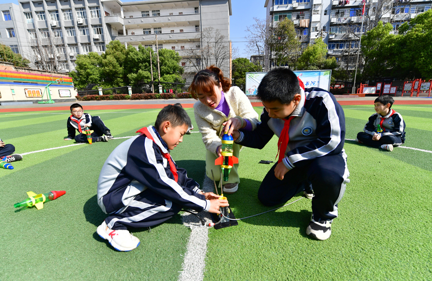 学生们跟着老师在操场上开展水火箭的制作与发射展示活动。鲍赣生摄