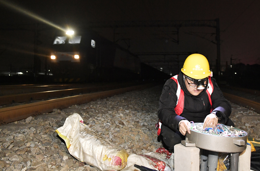 凌晨时分，施工人员正在铁路线旁进行新信号接入作业。 潘星摄