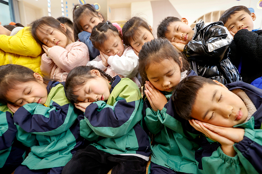 幼兒園的老師在指導小朋友們學習正確的睡眠姿勢。陳福平攝 