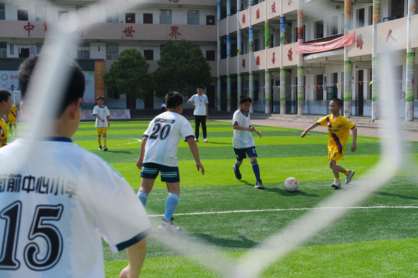 在遂川县衙前中心小学，师生们在足球场体验足球带来的快乐。李书哲摄