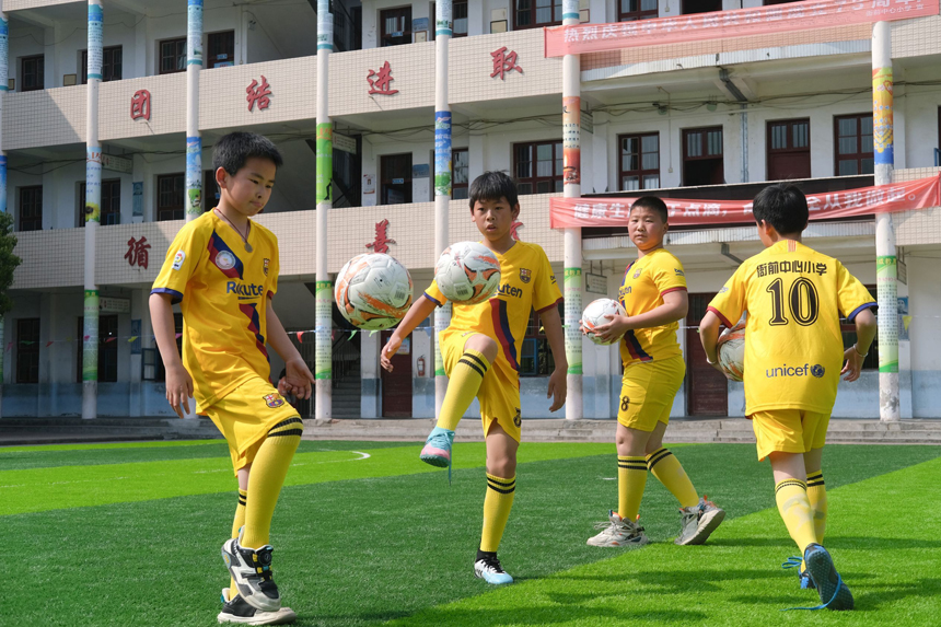 在遂川县衙前中心小学，师生们在足球场体验足球带来的快乐。李书哲摄