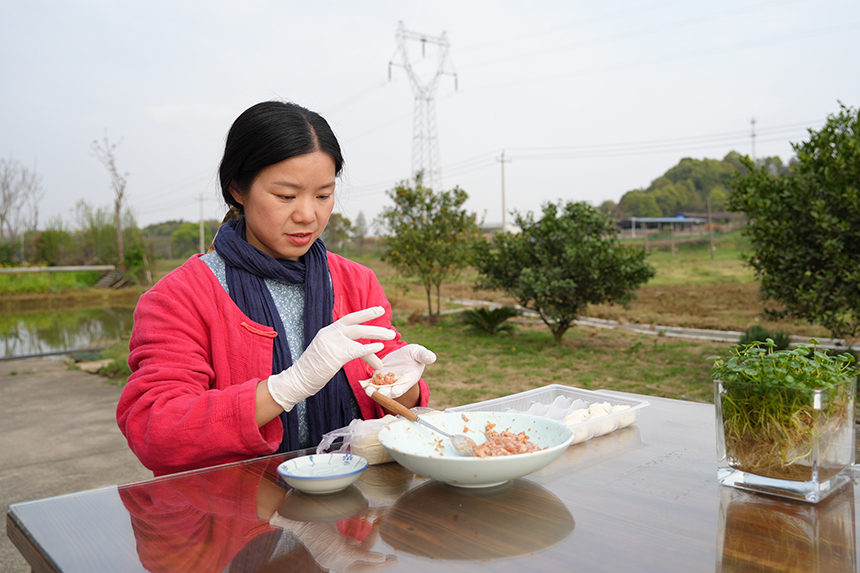 李宜玲正在小院里包饺子，招待客人。上高县委宣传部供图