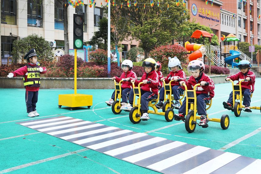 3月27日，江西省宜春市上高縣第八幼兒園的“小司機”們聽從小交警指揮，有序行駛。陳旗海攝