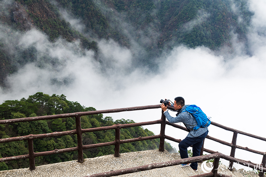 攝影愛好者在拍攝雲海景觀。人民網 孔文進攝