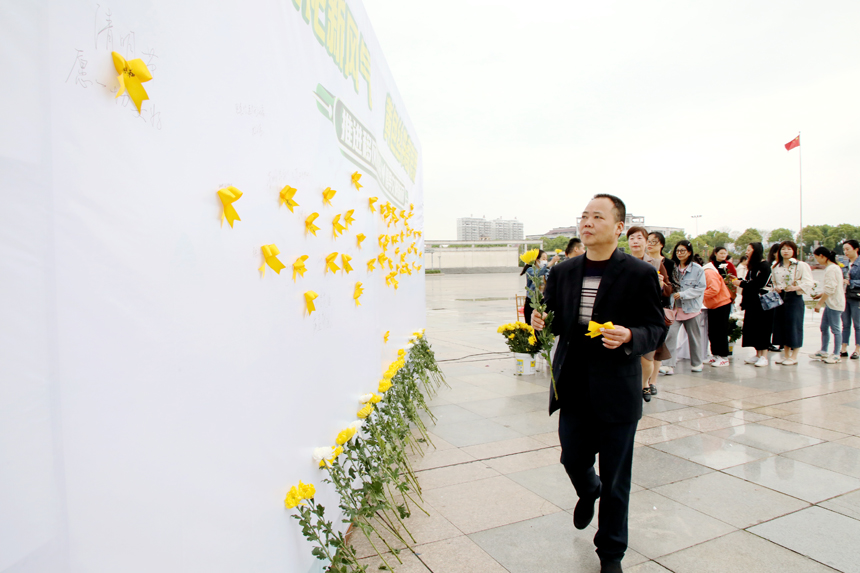 4月3日，廣昌縣廣大群眾在蓮花廣場將黃絲帶粘貼在追思牆上，用一束鮮花表達對故人的思念，並依次在追思牆上簽下自己的名字和祈福詞。地方供圖