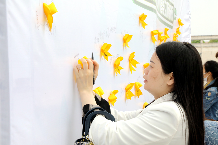 4月3日，廣昌縣廣大群眾在蓮花廣場將黃絲帶粘貼在追思牆上，用一束鮮花表達對故人的思念，並依次在追思牆上簽下自己的名字和祈福詞。地方供圖